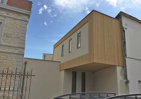 Volume bardé de bois en porte-à-faux entre deux bâtiments anciens